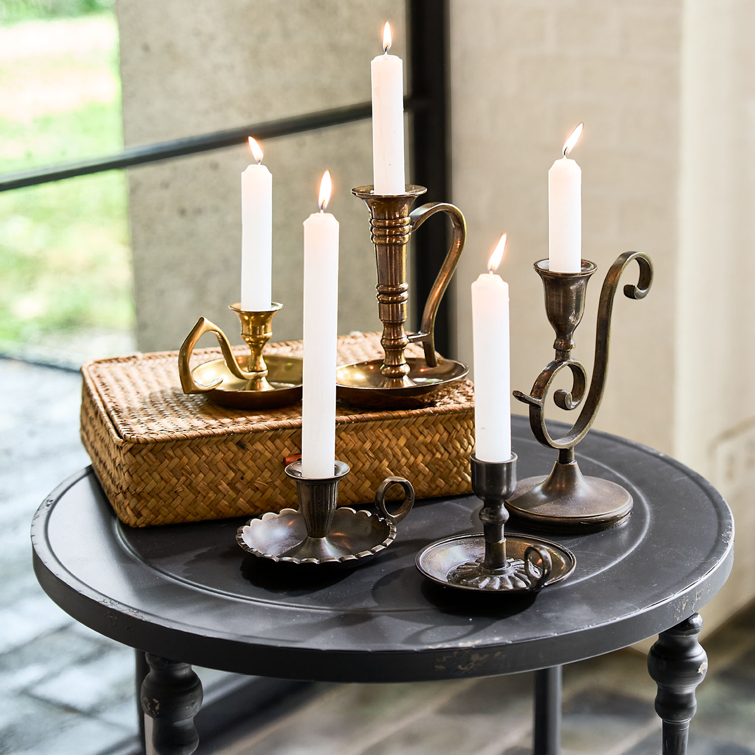 Ensemble de chandeliers en métal avec bougies blanches sur une table ronde noire pour décoration intérieure