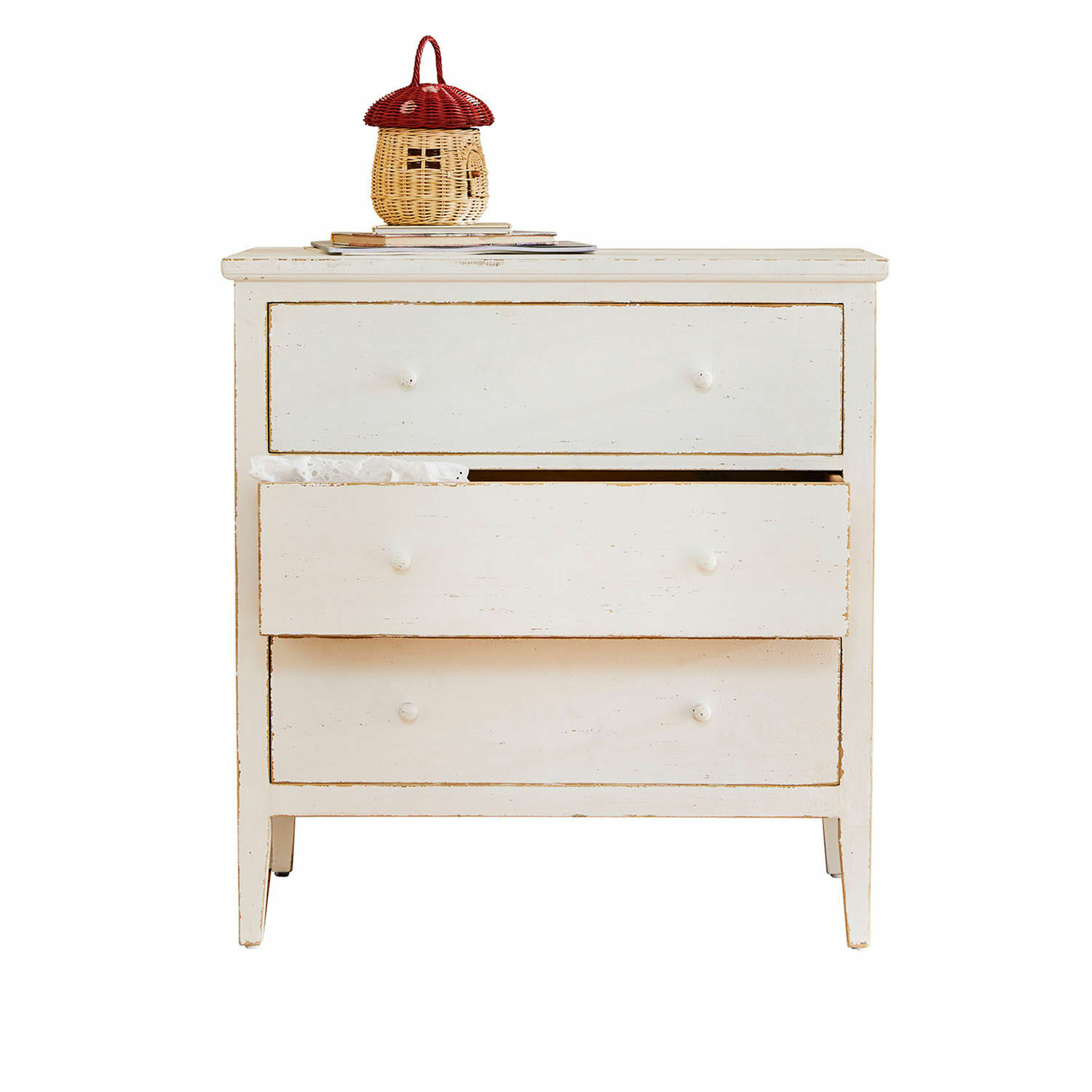 Ladekast Korelis Witte houten ladekast met drie laden en decoratieve mand op boeken, woonkamermeubel