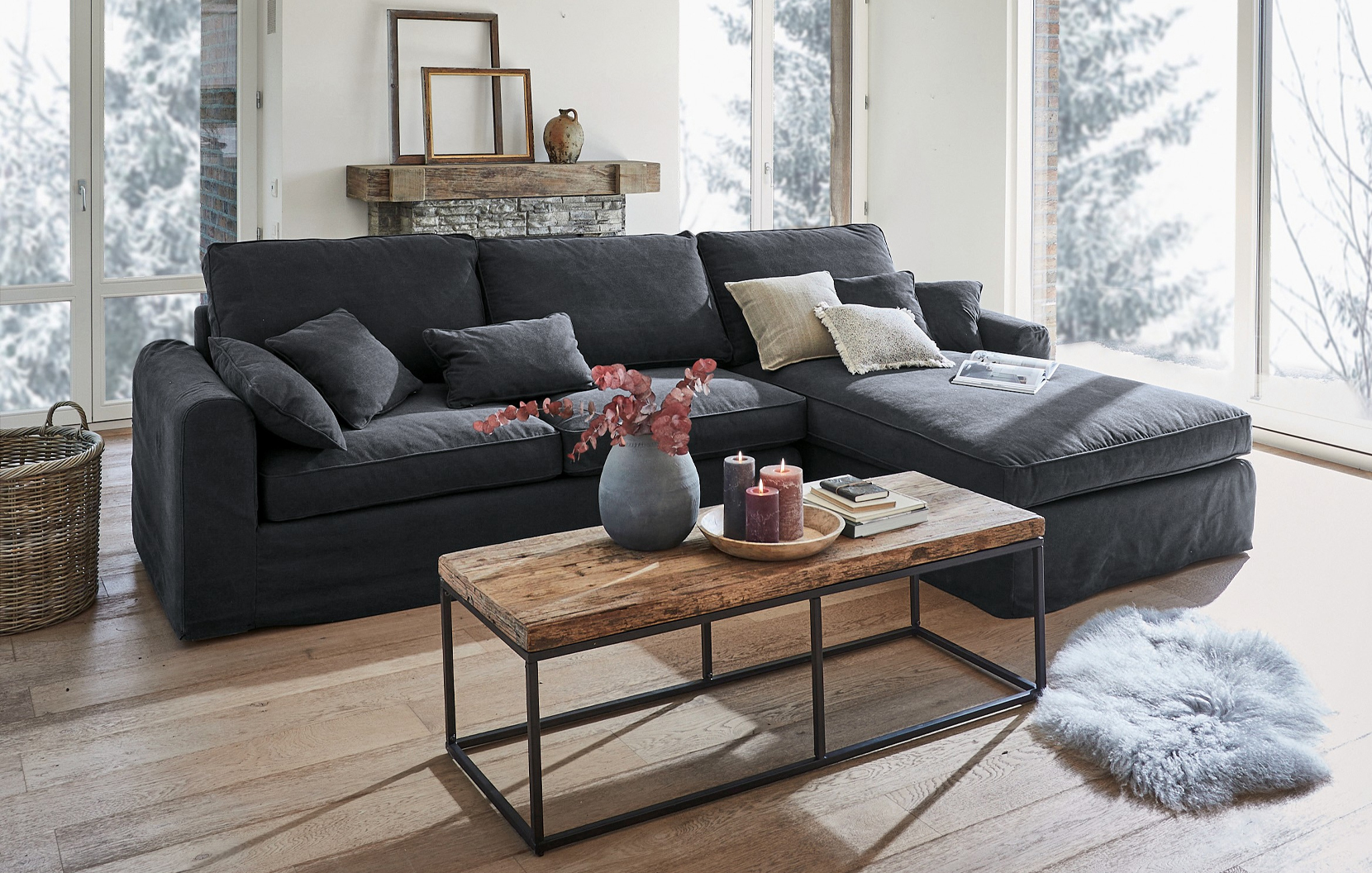 Canapé d'angle gris en tissu style industriel avec table basse en bois et décorations dans un salon lumineux