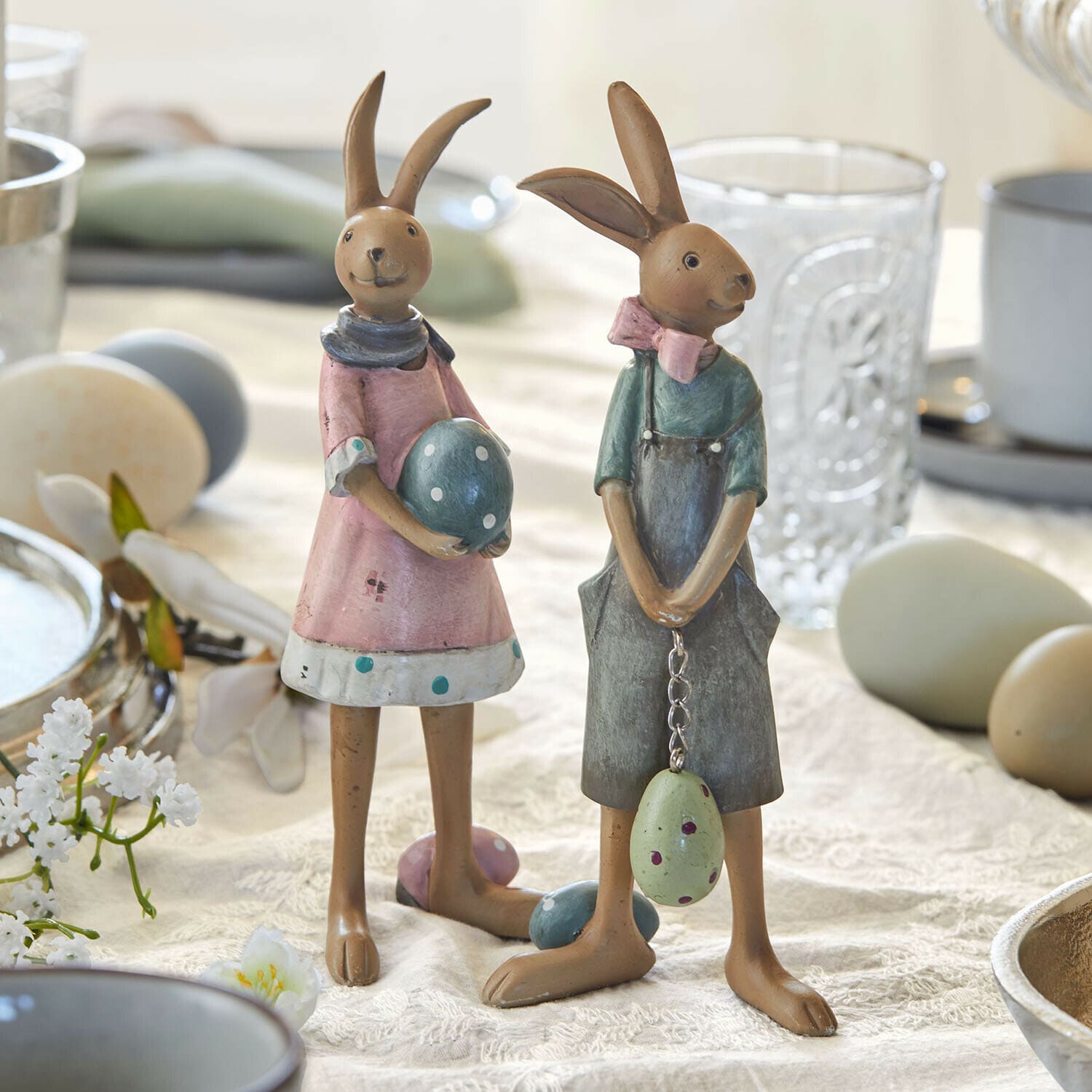 Haasje set van 2 Sivalex Twee decoratieve metalen konijnenfiguren in pasteltinten met paaseieren op een tafel