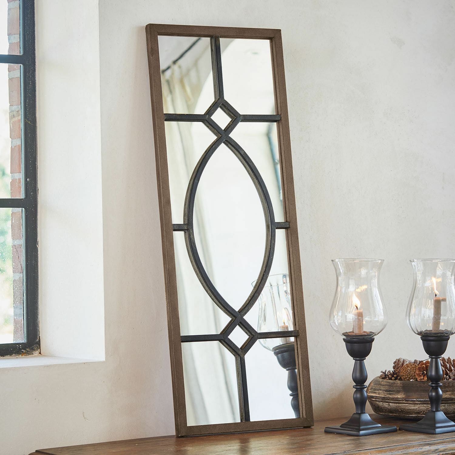 Spiegel Millery Rechthoekige spiegel met bruine houten lijst en zwart metalen patroon op tafel met lantaarns