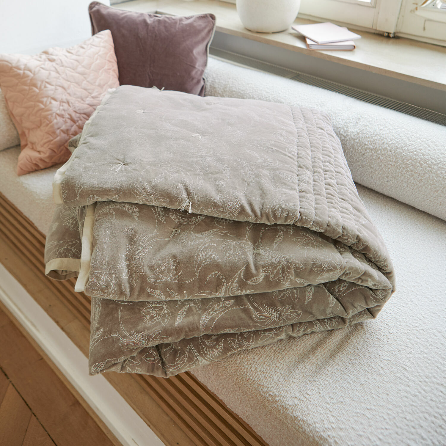 Quilt Olicianne Beige gewatteerde plaid met fijn bloemenpatroon op lichte bank in woonkamer