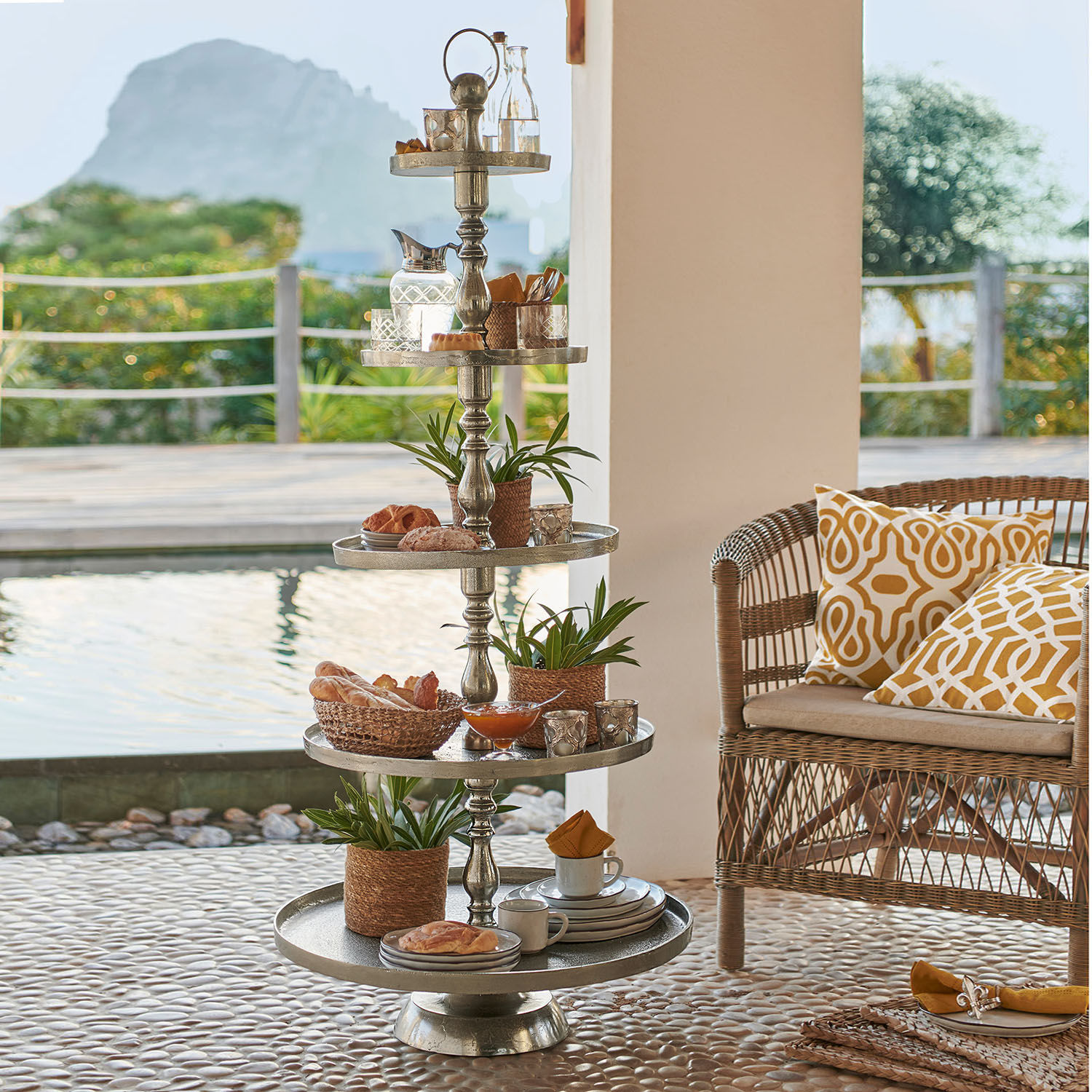 Présentoir à étages Magonie Présentoir métallique à cinq niveaux avec décorations et collations sur terrasse près de la piscine