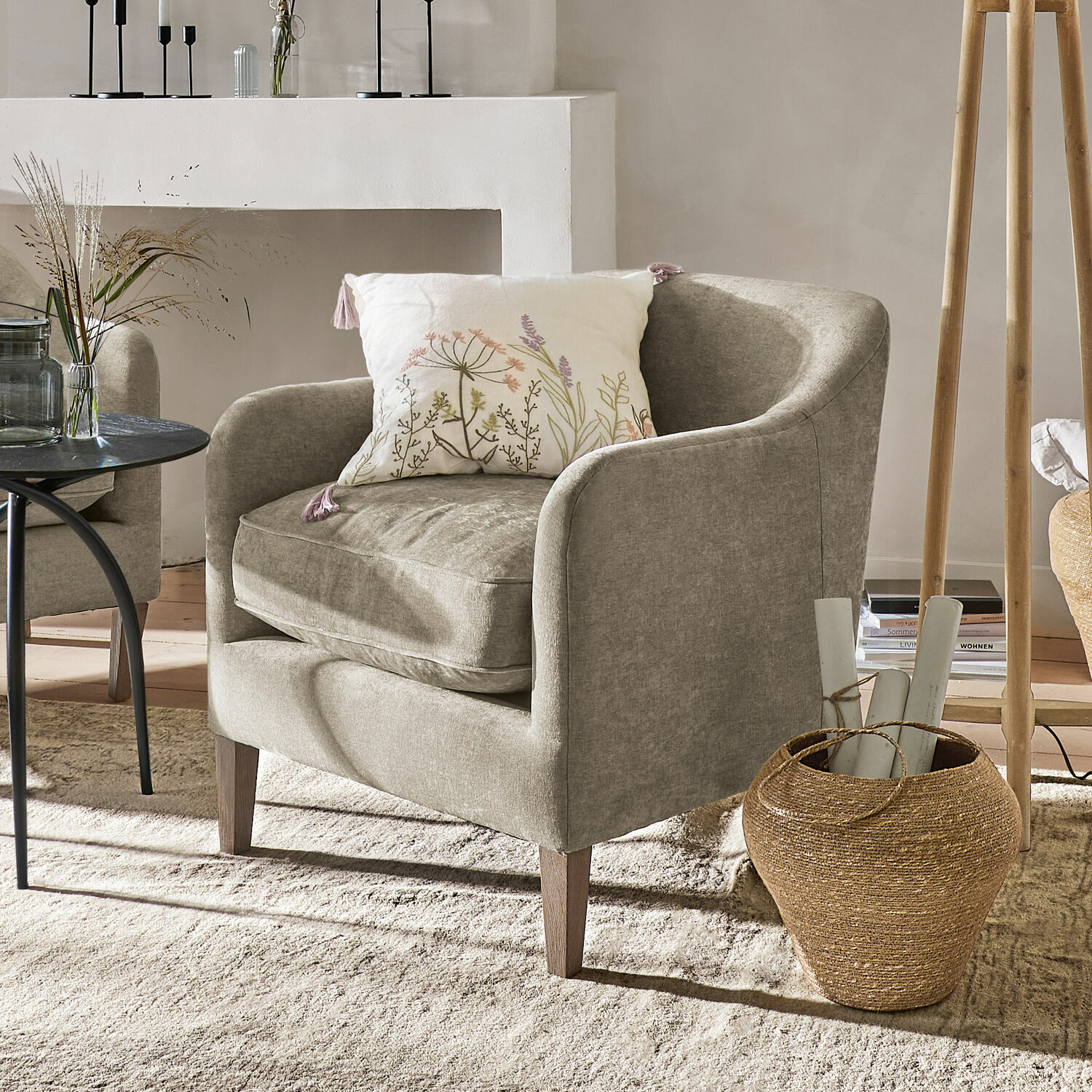 Fauteuil Jefferson Beige gestoffeerde fauteuil met bloemkussen in een gezellige, lichte woonkamer