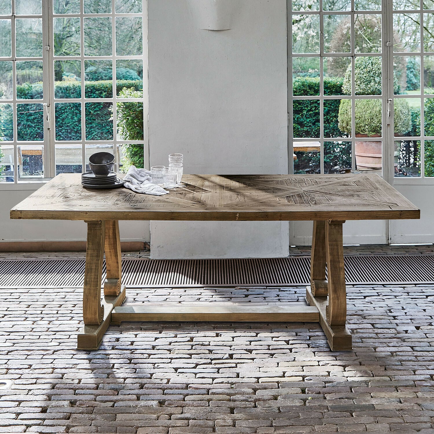 Tafel Campbelltown Houten tafel in natuurlijke kleur met decoratief blad voor grote ramen en een bakstenen vloer
