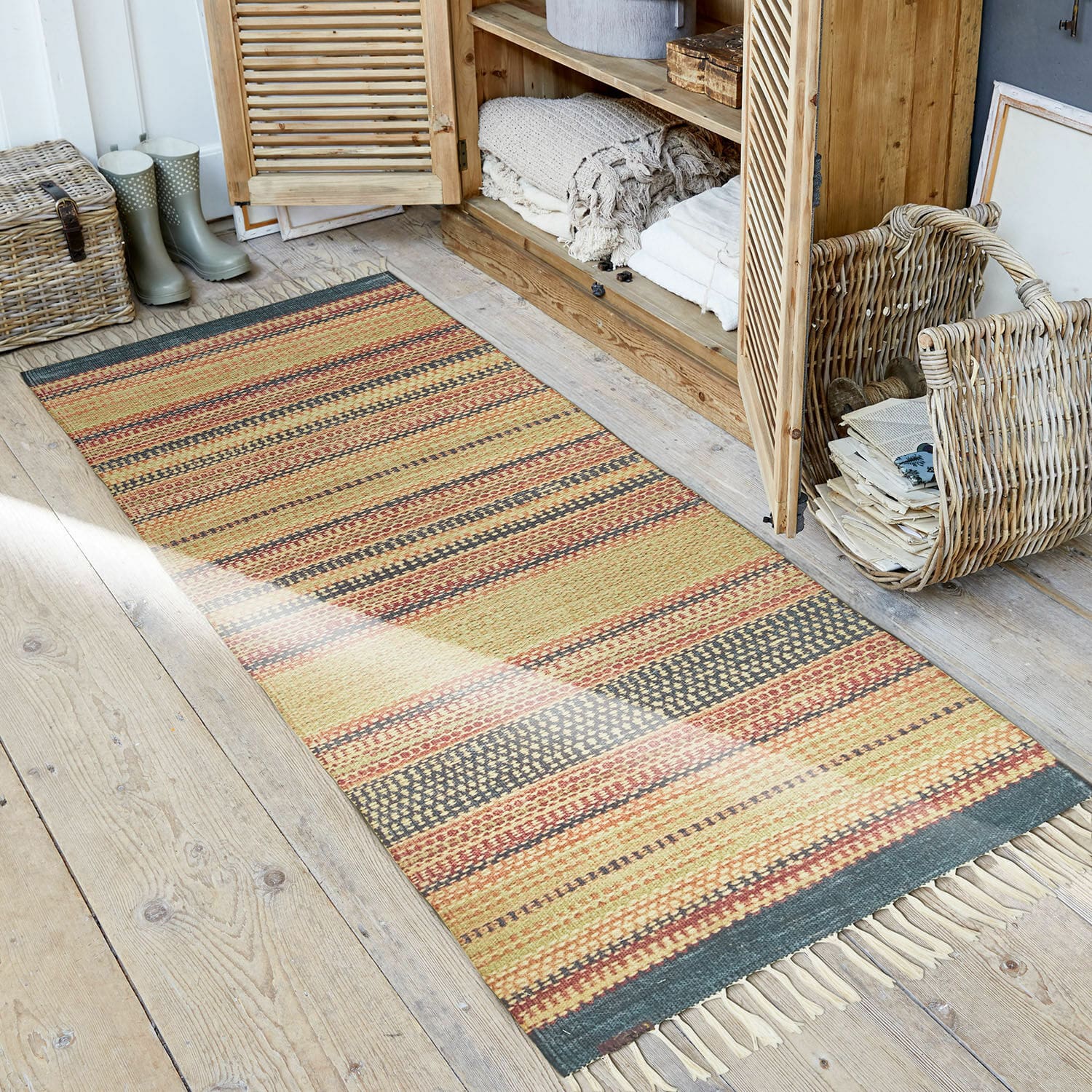 In- & outdoor loper Atlanta Gestreept vloerkleed in warme kleuren met franjes op houten vloer in rustieke ruimte