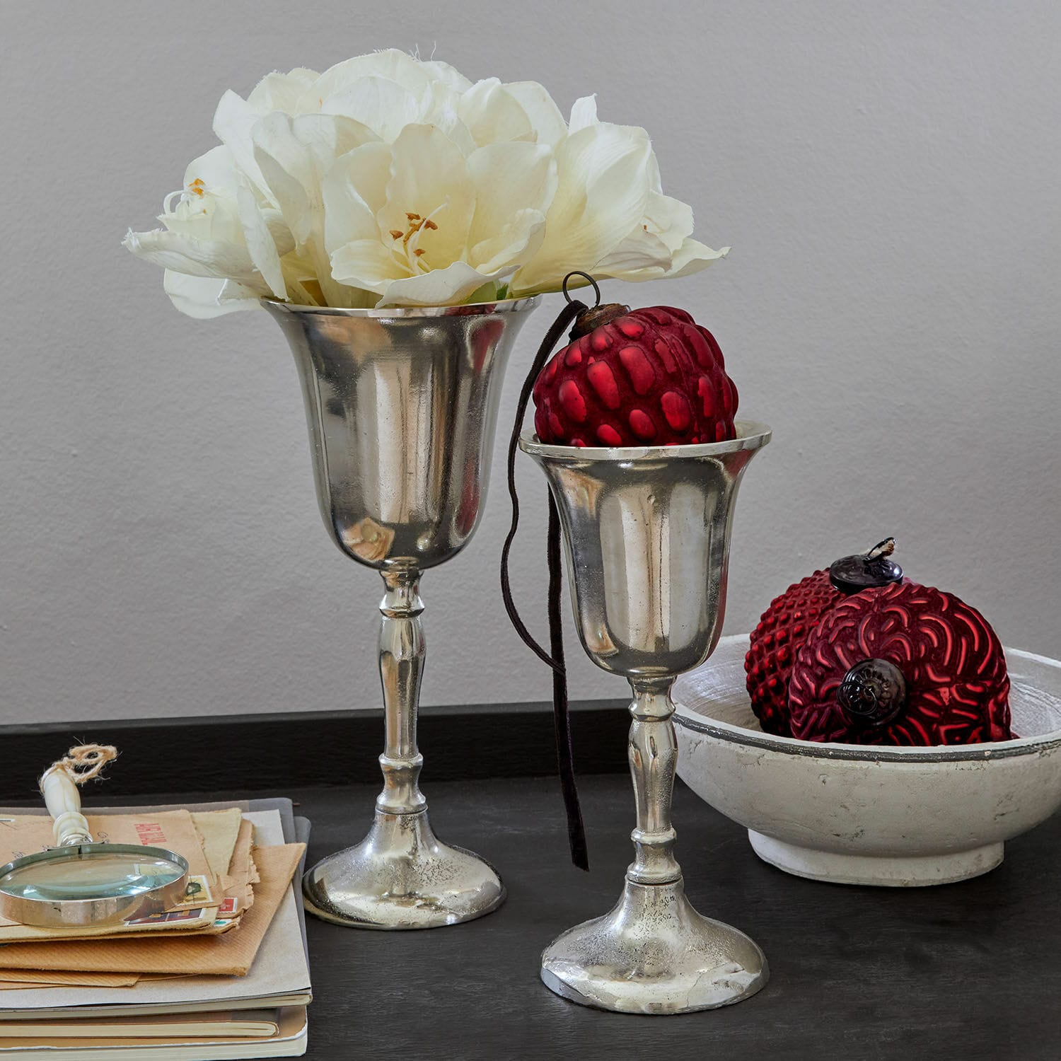 Vaas set van 2 Solérie Twee zilveren decoratieve kelken met witte bloemen en rode versieringen op zwarte tafel