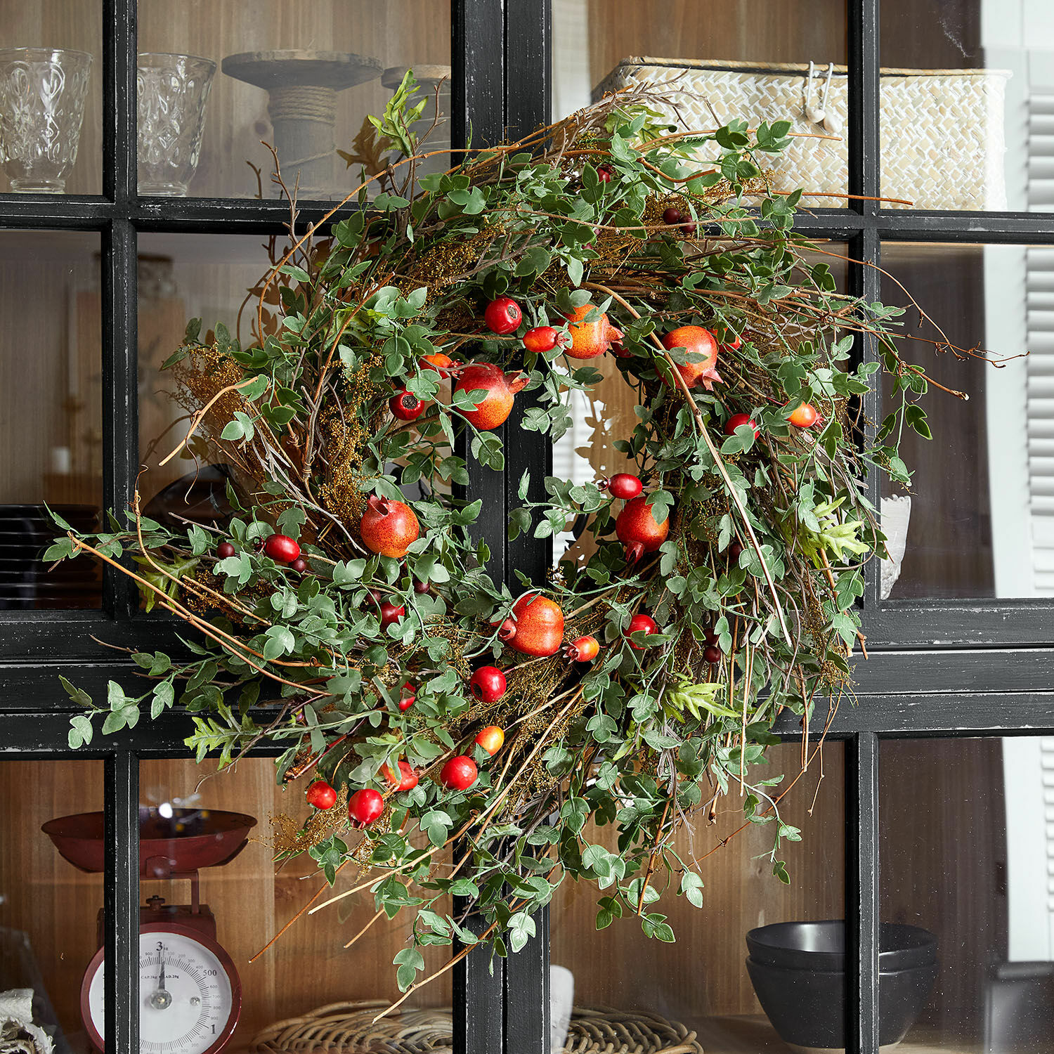 Couronne Karidah Couronne décorative en feuillage vert et fruits rouges sur porte noire, décoration intérieure naturelle