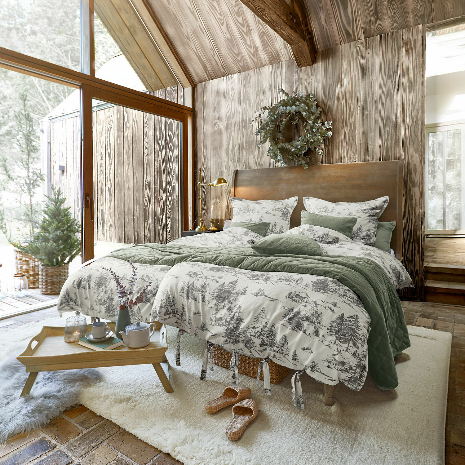 Dekbedovertrekset Héroux Gezellige slaapkamer met houten wand en bed met groen-grijs beddengoed met bosmotief