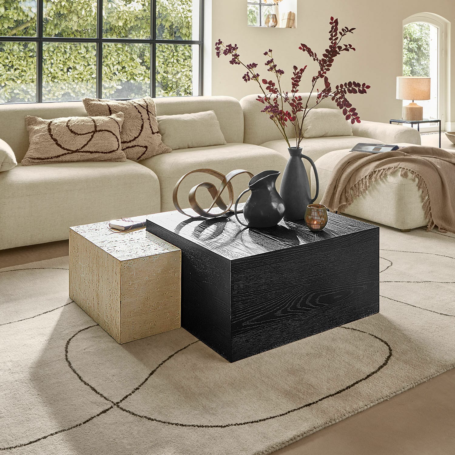 Salontafel Caleneuve Moderne woonkamer met beige bank en twee salontafels van hout en steen, decoraties op tafel