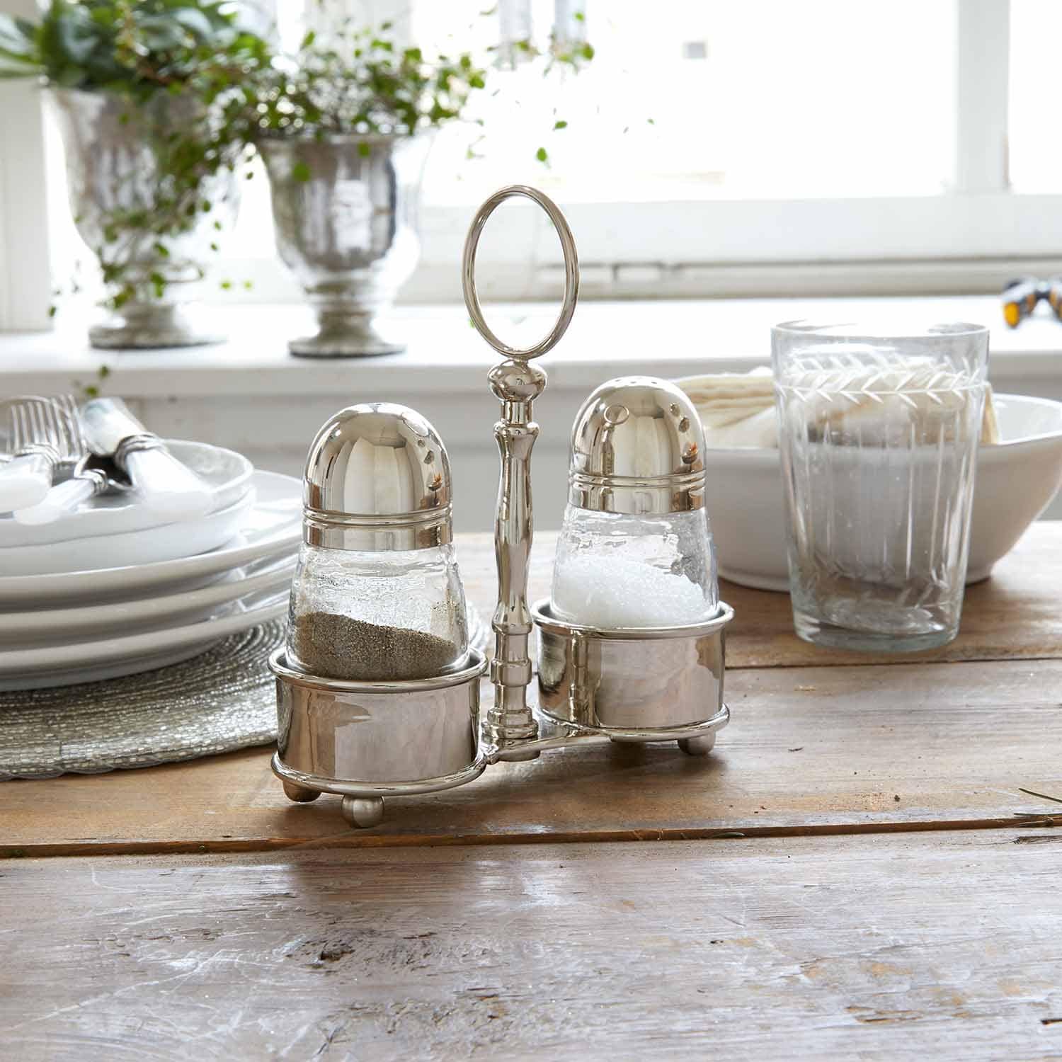 Zout- en peperstel van roestvrij staal op houten tafel in lichte keuken