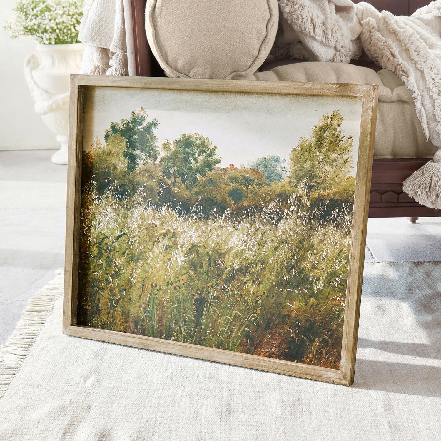 Tableau Vallerine Tableau paysage avec arbres verts et prairie encadré en bois posé sur un tapis clair