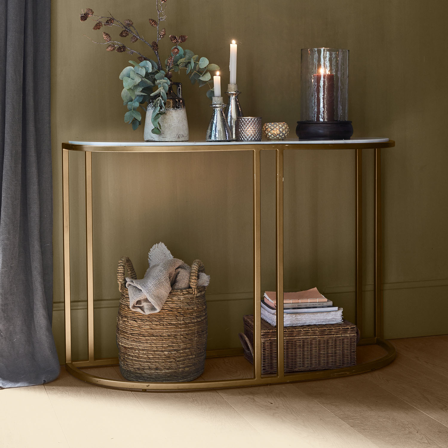 Consoletafel met wit marmeren blad en gouden metalen frame, versierd met kaarsen en stoffen mand