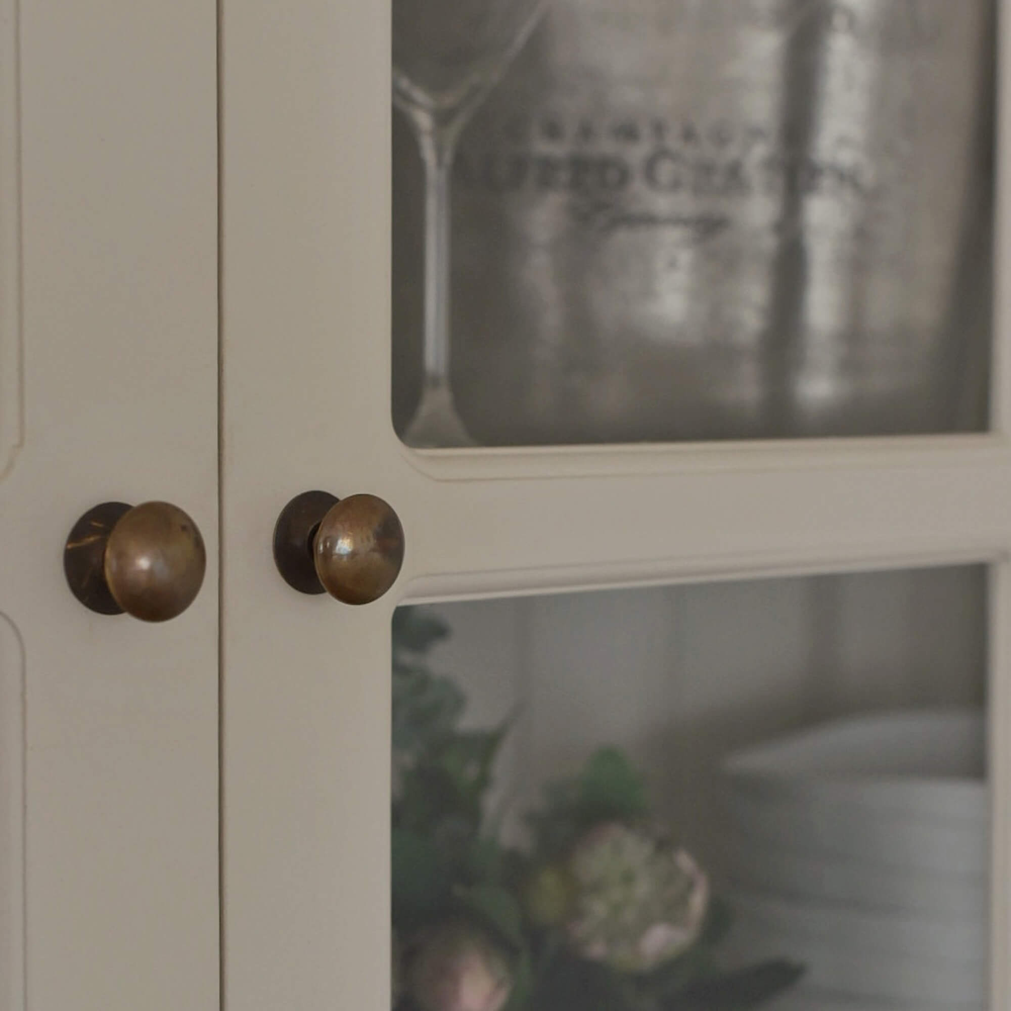 Detail van witte houten kast met messing knoppen, rustieke stijl, opbergmeubel
