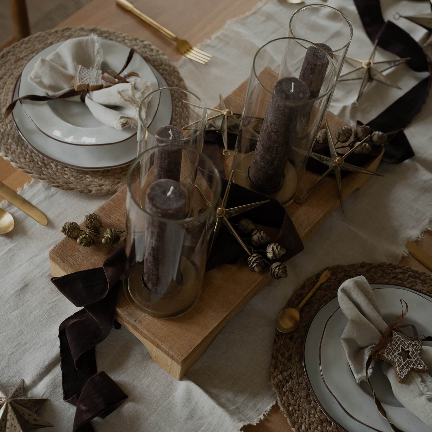 Table de Noël décorée avec bougies brunes en verre et éléments naturels pour ambiance chaleureuse