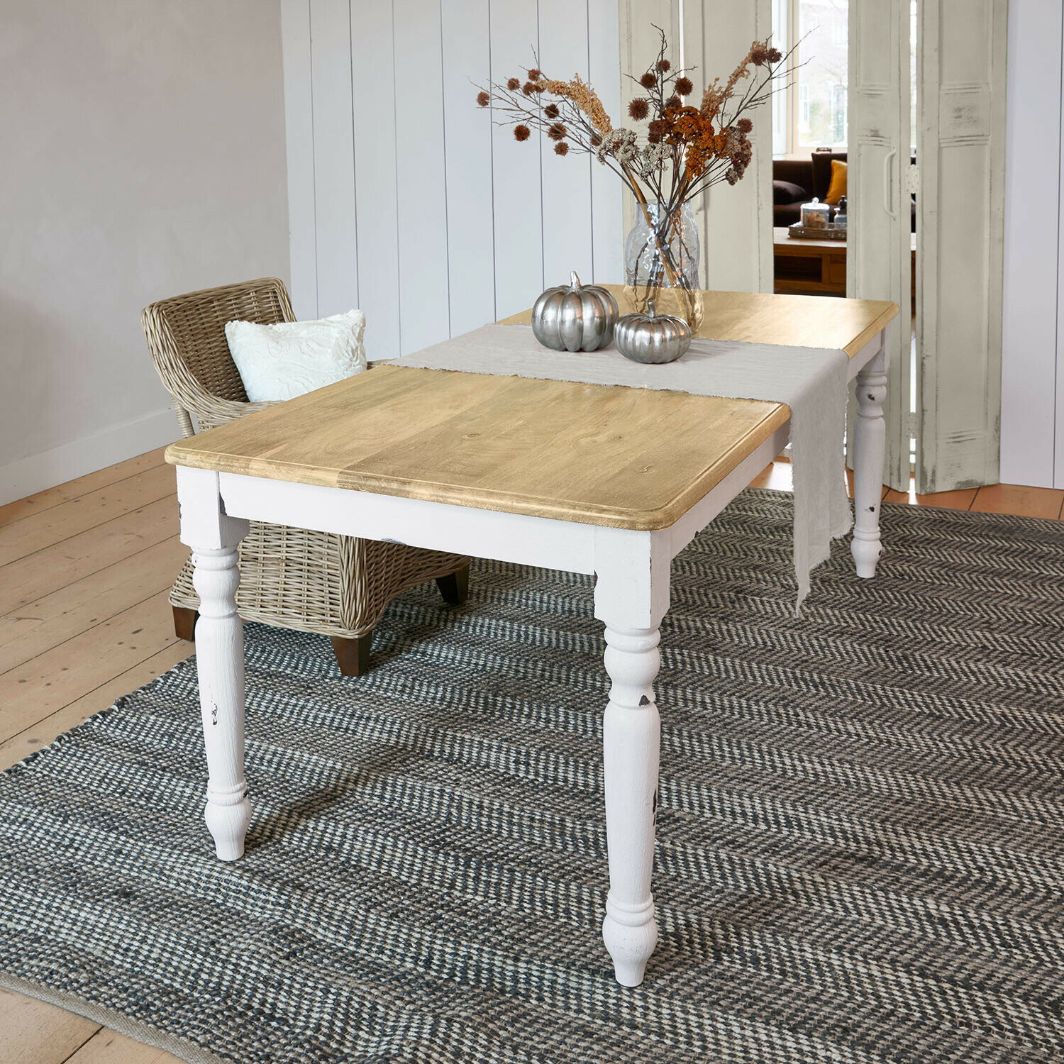 Houten tafel met witte poten en naturel blad, versierd met zilveren pompoenen en gedroogde bloemen