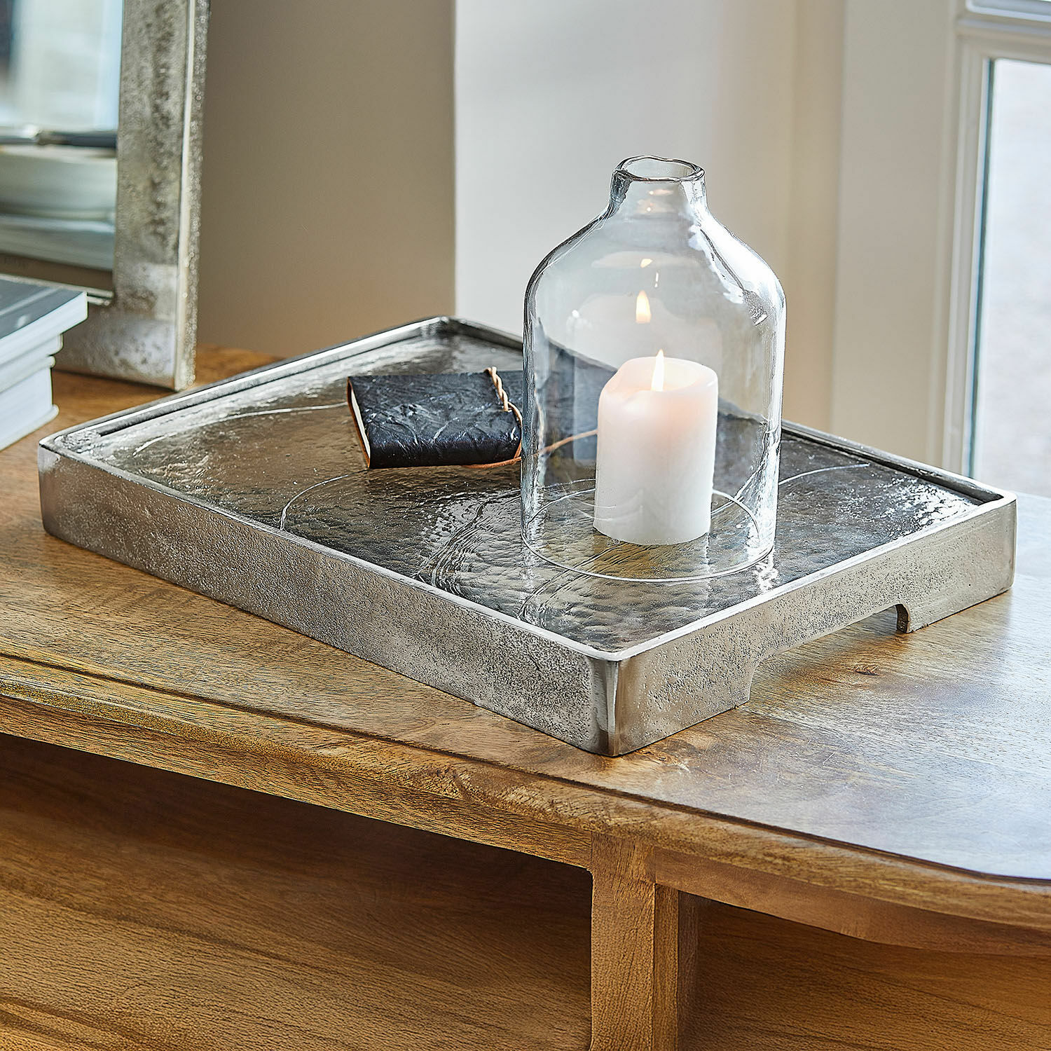 Dienblad Yvelissel Decoratief zilverkleurig metalen dienblad met doorzichtige glazen stolp en witte kaars op houten tafel