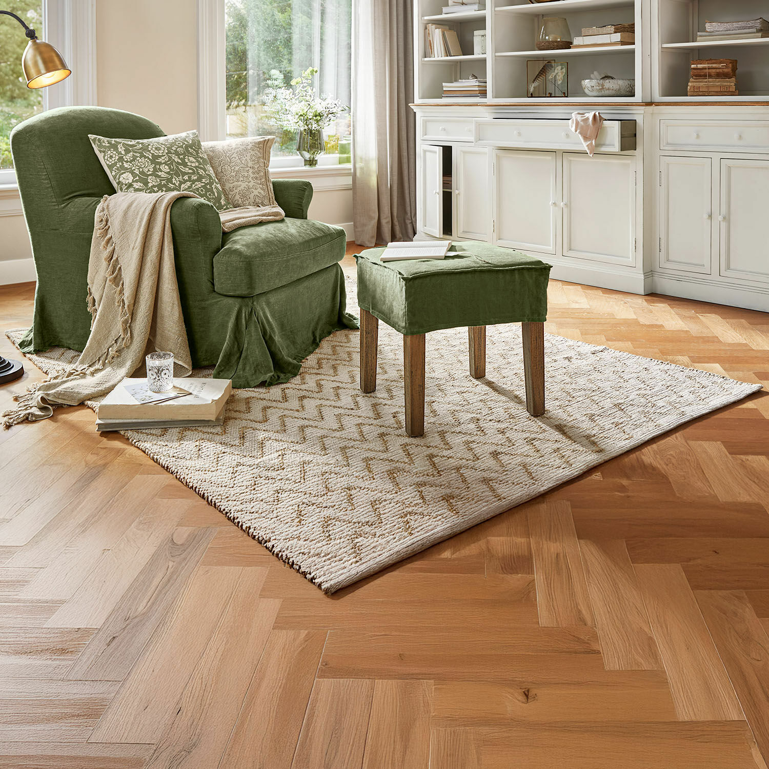 Omkeerbaar vloerkleed Vendeline Groene stoffen fauteuil en voetenbankje in gezellige woonkamer met vloerkleed en houten vloer