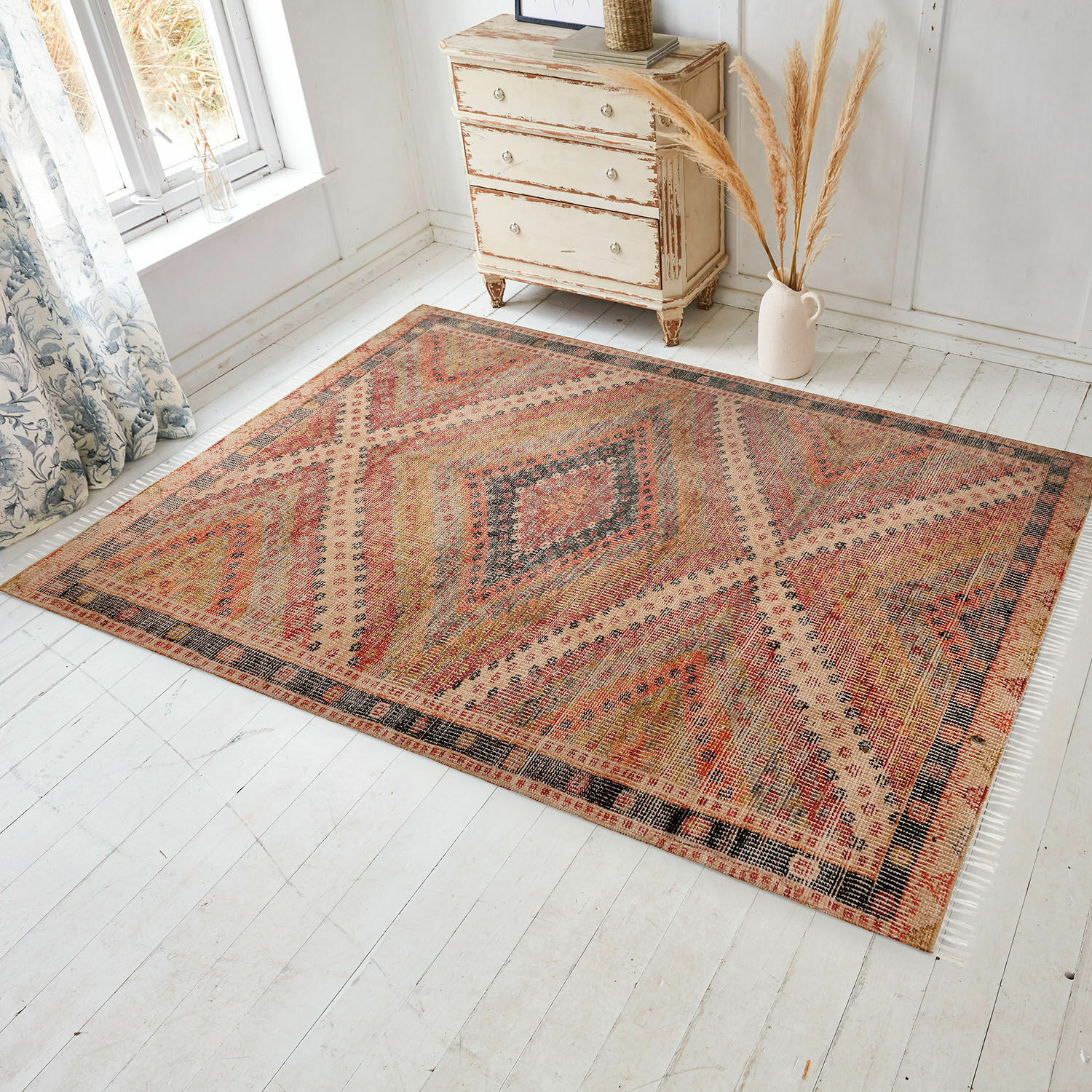 Vloerkleed voor binnen en buiten Mildura Vloerkleed met geometrisch patroon in warme rood- en beigetinten op lichte houten vloer