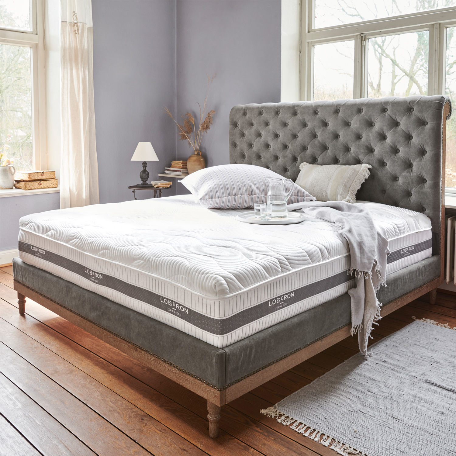 Matras met topper 180x200 Raillimont Bed met grijs gestoffeerd hoofdeinde en wit Loberon matras in lichte kamer met houten vloer