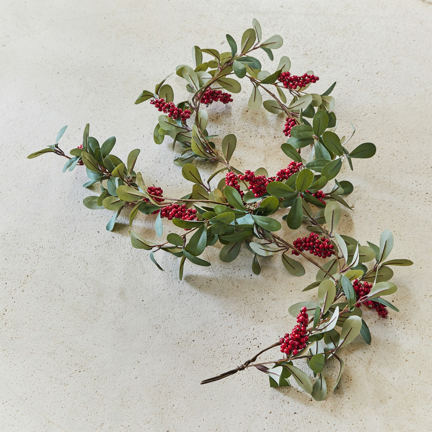Guirlande Lenius Decoratieve slinger met groene bladeren en rode bessen op lichte achtergrond, feestelijke decoratie