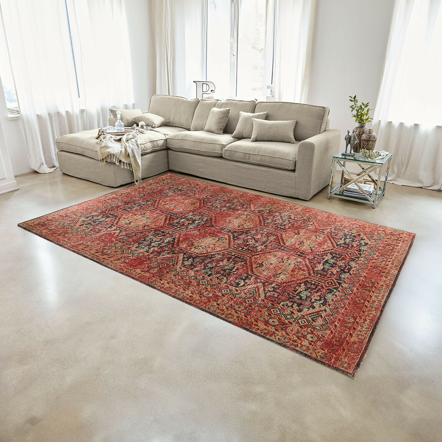 Tapis Incantaro Tapis rouge à motif oriental sur sol clair dans un salon moderne avec canapé beige
