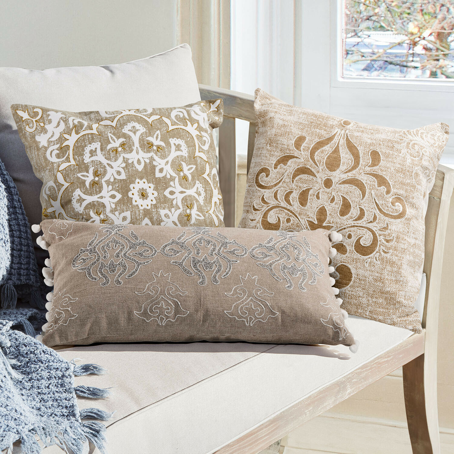 Lot de 3 housses de coussins Emelin Canapé beige avec coussins décoratifs pastel et un châle doux posé sur l'assise