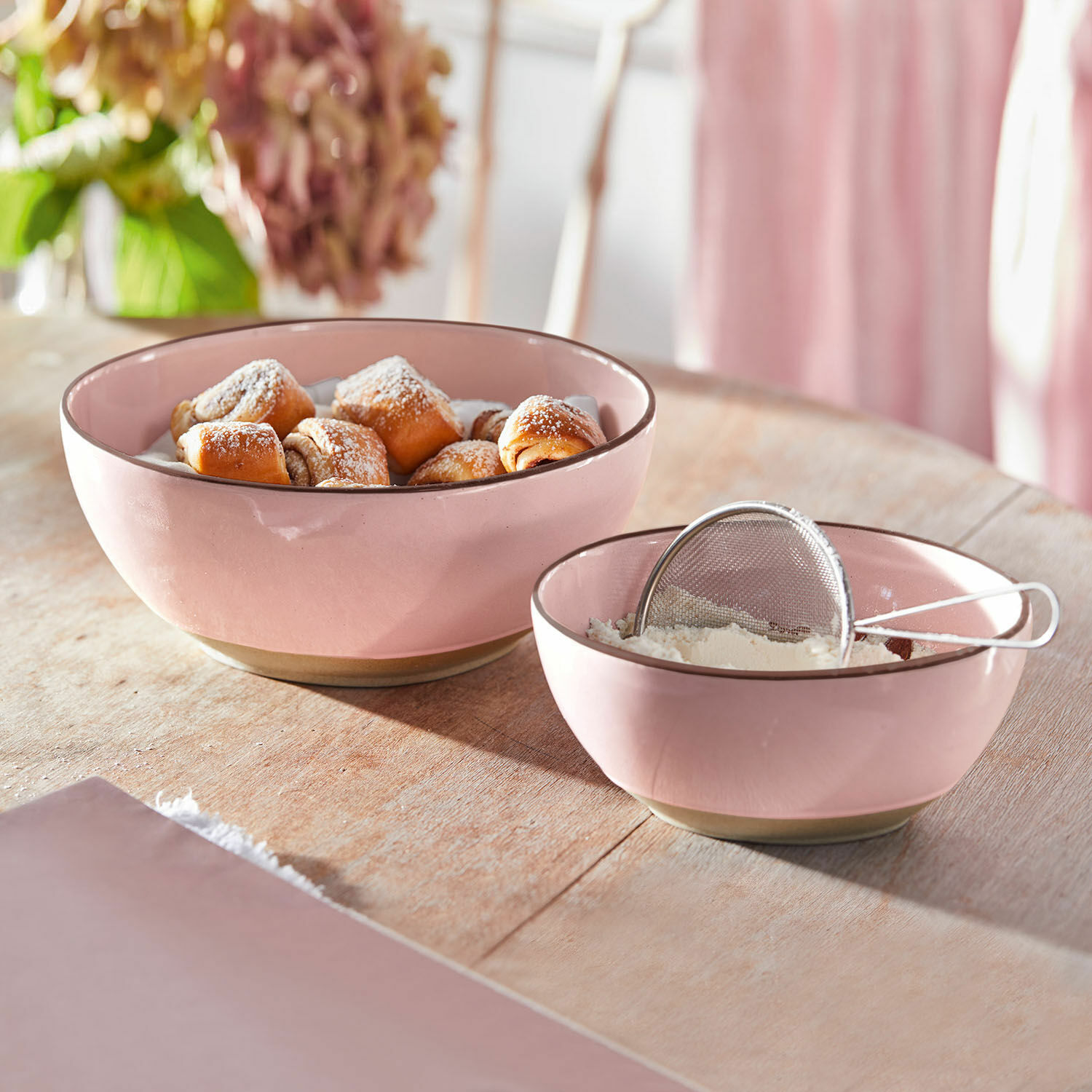 Lot de 2 saladiers Biarré Bols en céramique rose contenant des pâtisseries et de la farine sur une table en bois