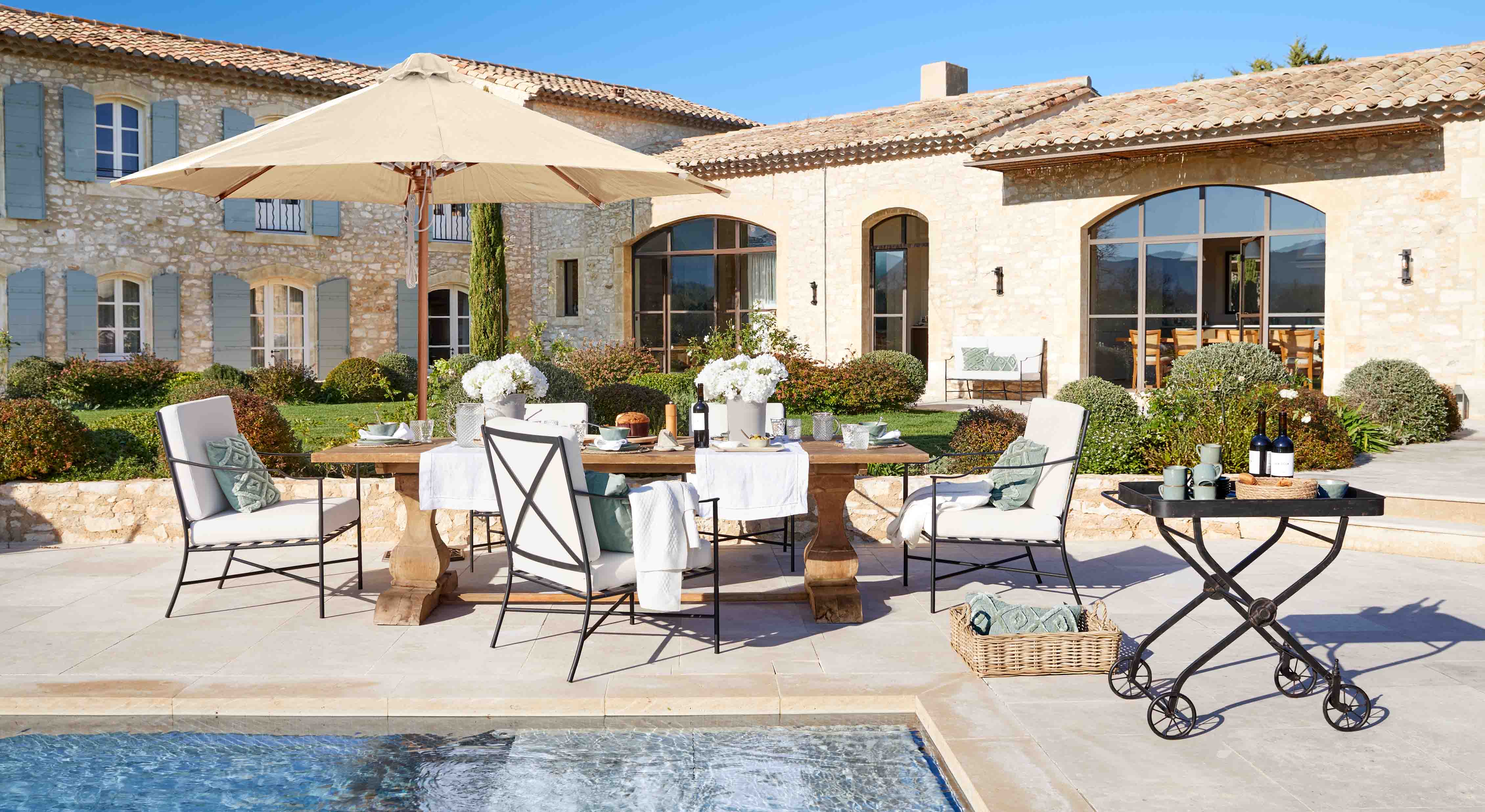 Ensemble de mobilier de jardin élégant avec parasol beige et table en bois près de la piscine