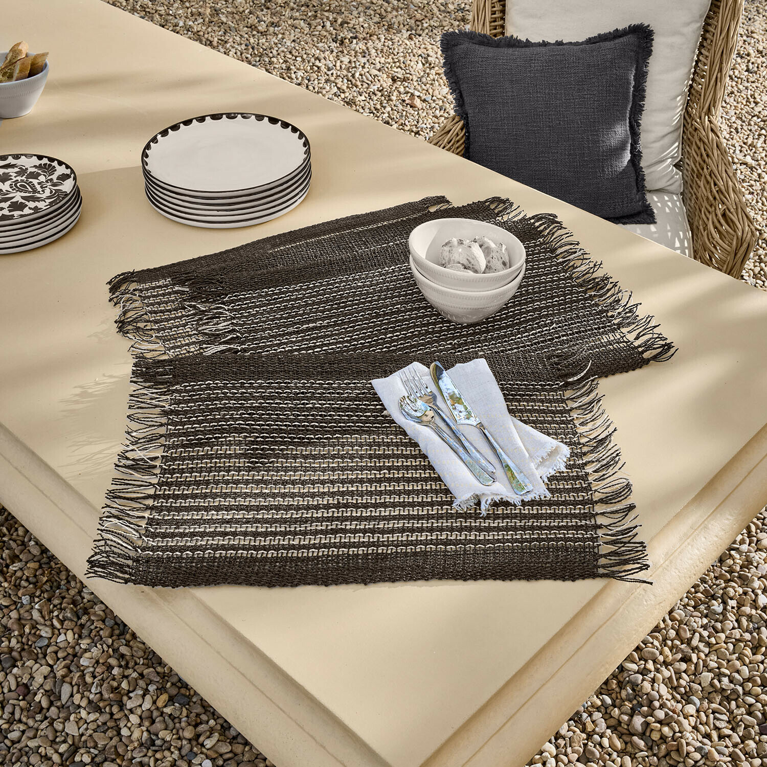 Placemat set van 4 Tarevo Bruine geweven placemats met franjes op beige tafel met servies en bestek