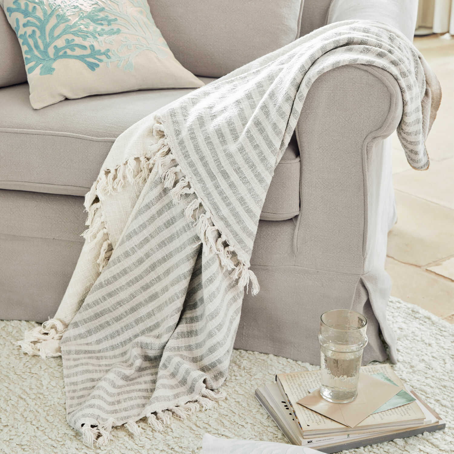 Plaid Marpent Beige gestreept deken met franjes op lichtgrijze bank, gezellige woonaccessoire