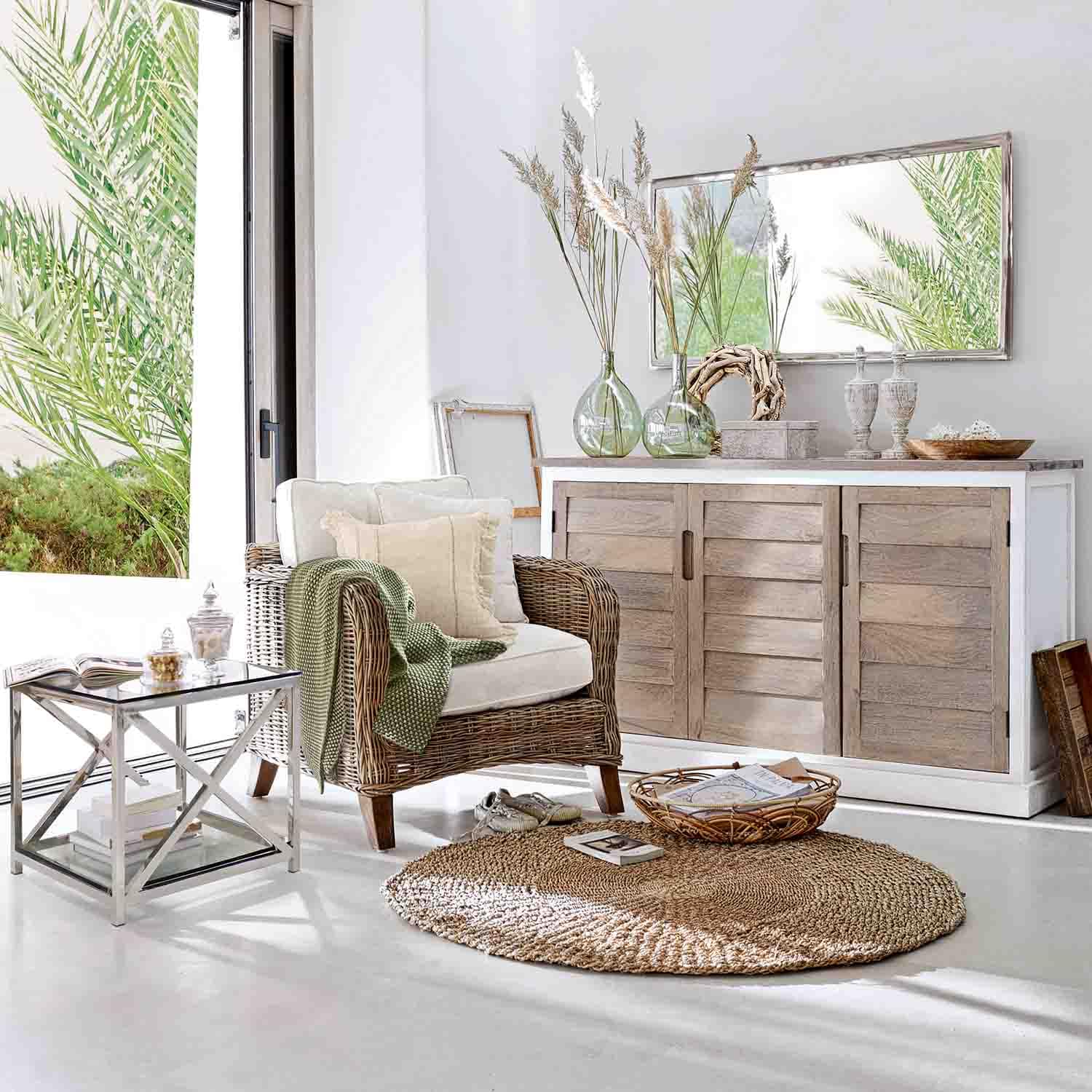 Salon lumineux avec fauteuil en osier, buffet en bois clair et tapis naturel rond pour décoration cosy