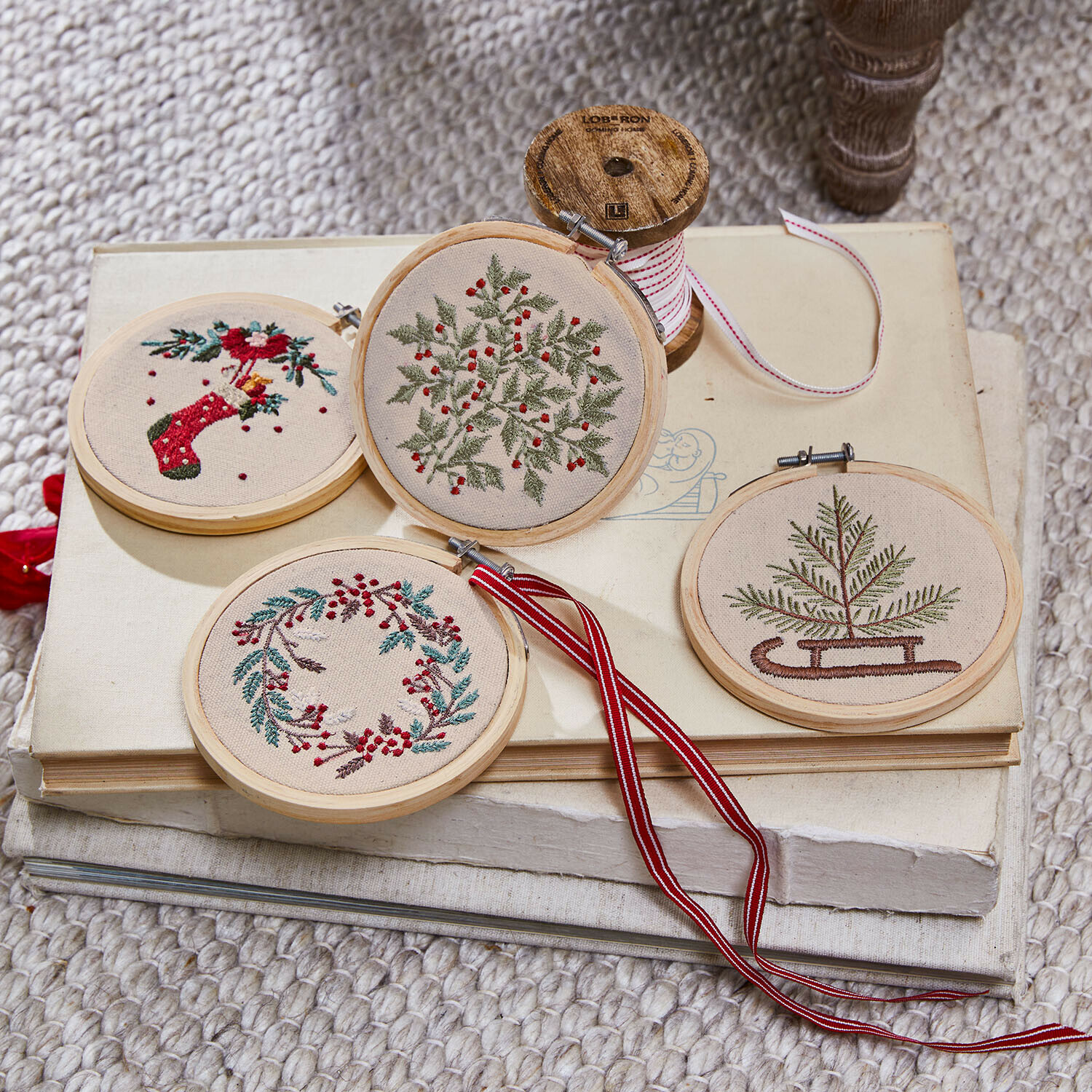 Lot de 4 décorations Seravas Quatre décorations brodées de Noël avec motifs végétaux sur toile beige et cadre en bois clair