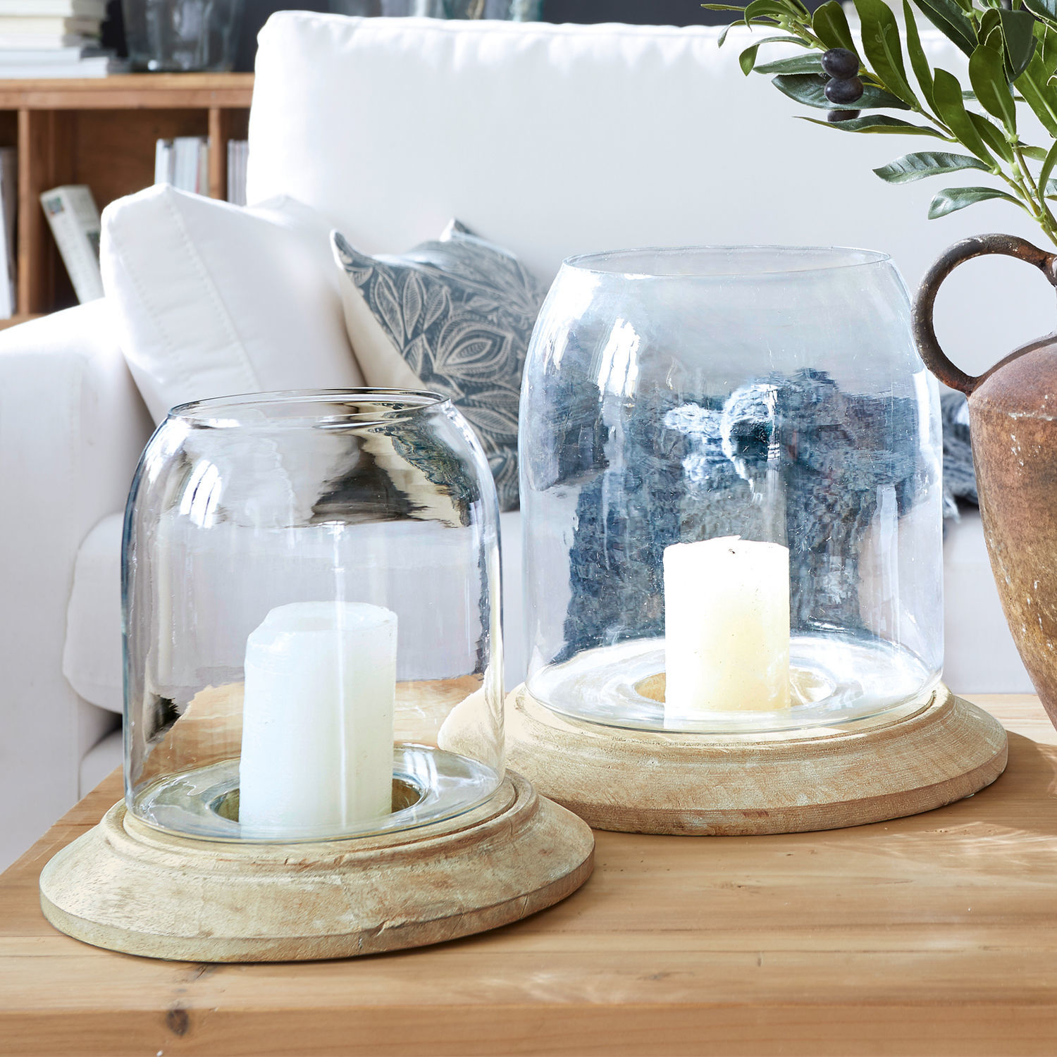 Lot de 2 photophores Bran Deux photophores en verre et bois naturel posés sur une table en bois dans un salon lumineux