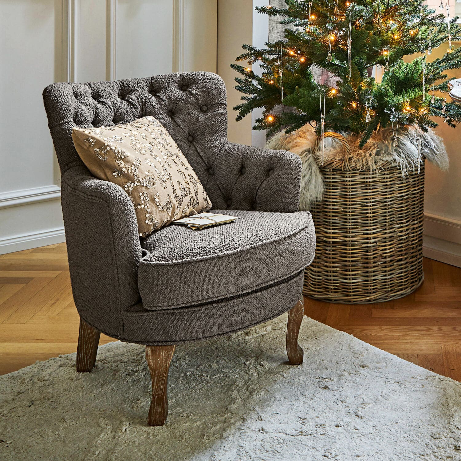 Fauteuil Calgary Fauteuil gris en tissu avec pieds en bois sur tapis clair près d'un sapin de Noël décoré