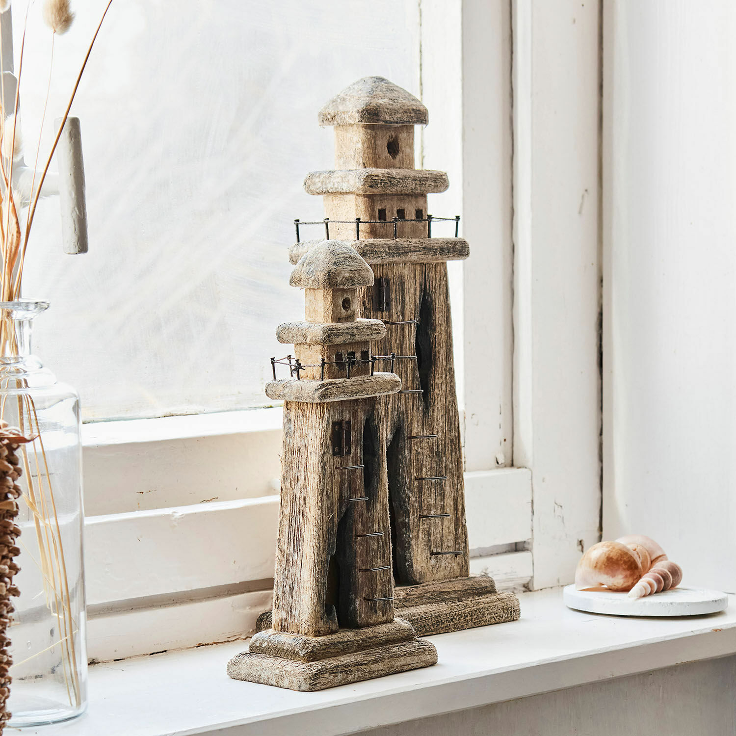 Siervuurtoren set van 2 Bourgneuf Twee decoratieve houten vuurtorens in natuurlijke kleur op vensterbank met schelpen