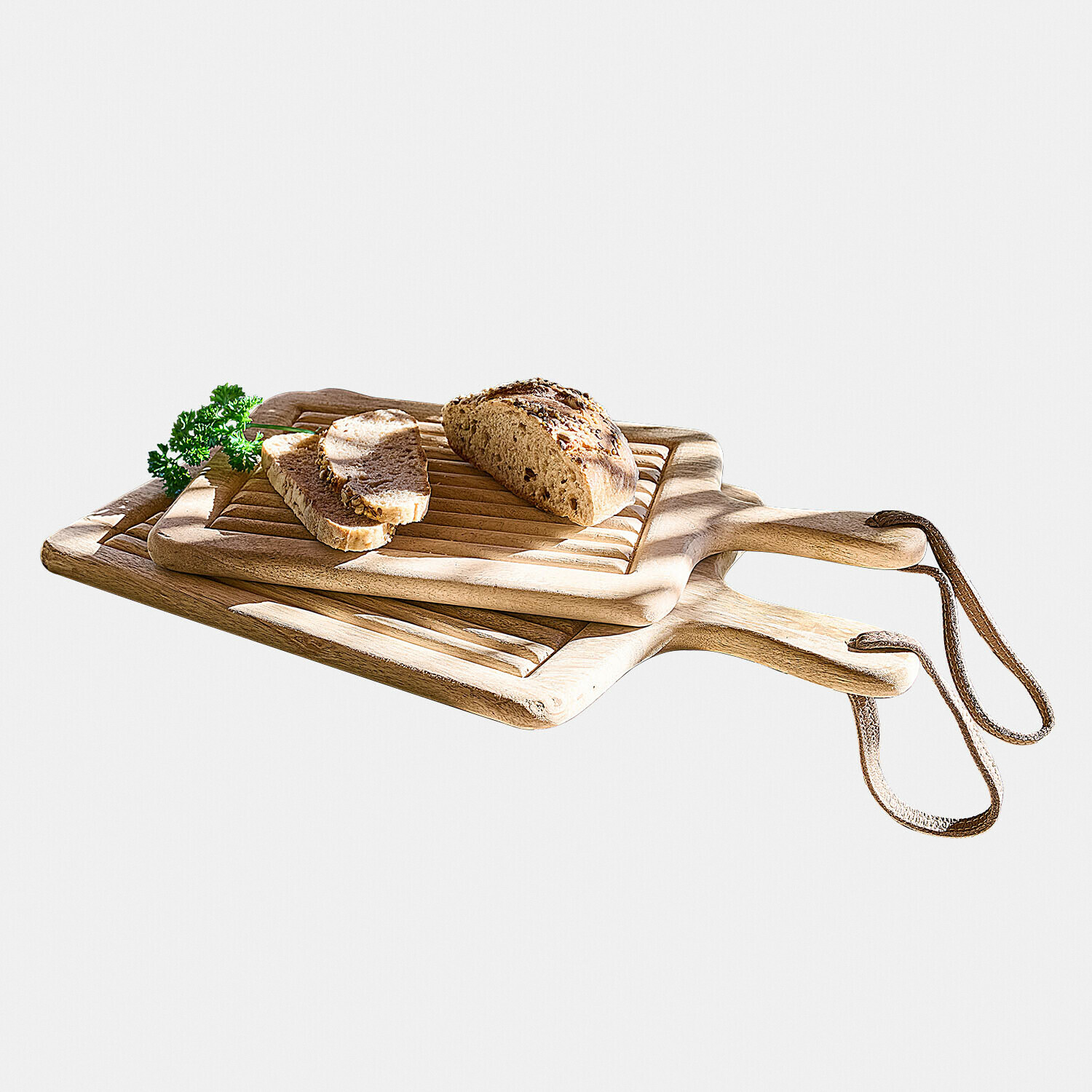 Snijplank set van 2 Vianzo Houten snijplanken met handvatten en leren lus, gesneden brood en verse peterselie erop, natuurlijke kleur