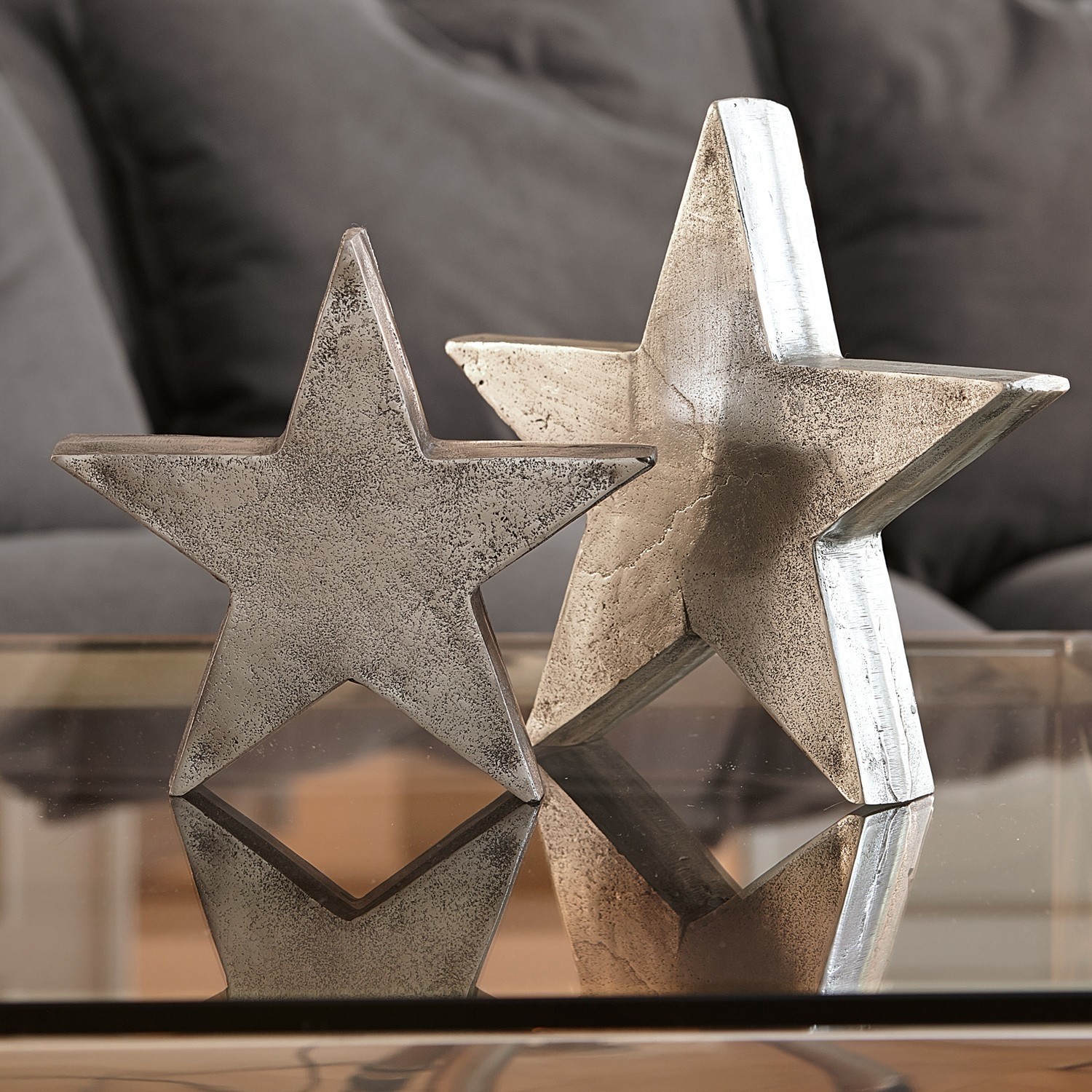 Lot de 2 décorations en forme d'étoile Big Star Étoiles décoratives en métal argenté posées sur une table en verre, décoration intérieure