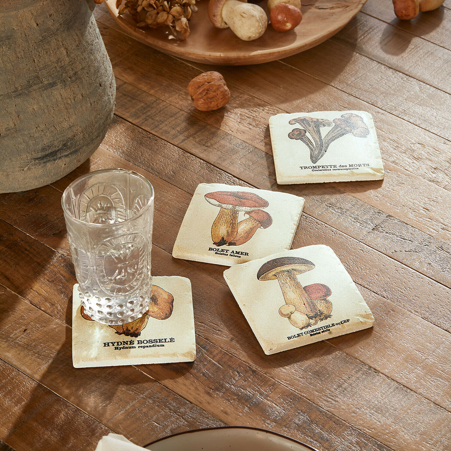 Onderzetter set van 4 Jandoria Onderzetters met paddenstoelillustraties op houten tafel met helder glas en noten