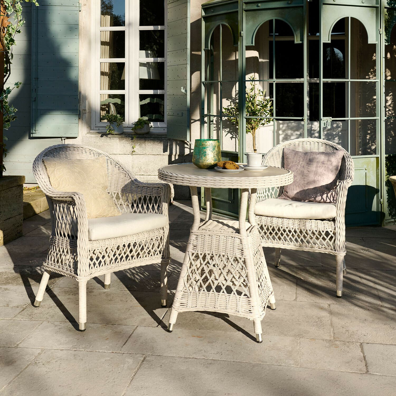 Zithoek Solavine Witte rotan tuinset met kussens, ronde tafel en twee stoelen op terras