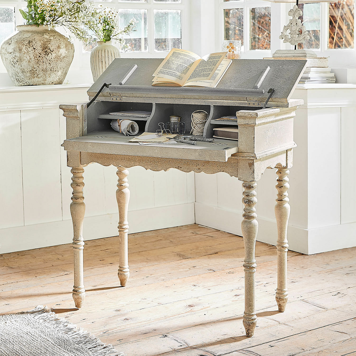 Console Arterton Bureau en bois vintage beige clair avec plateau ouvert et compartiments pour documents dans une pièce lumineuse