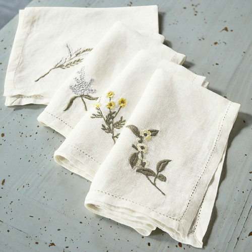 Set witte linnen servetten met geborduurde bloemen, natuurlijke tafeldecoratie
