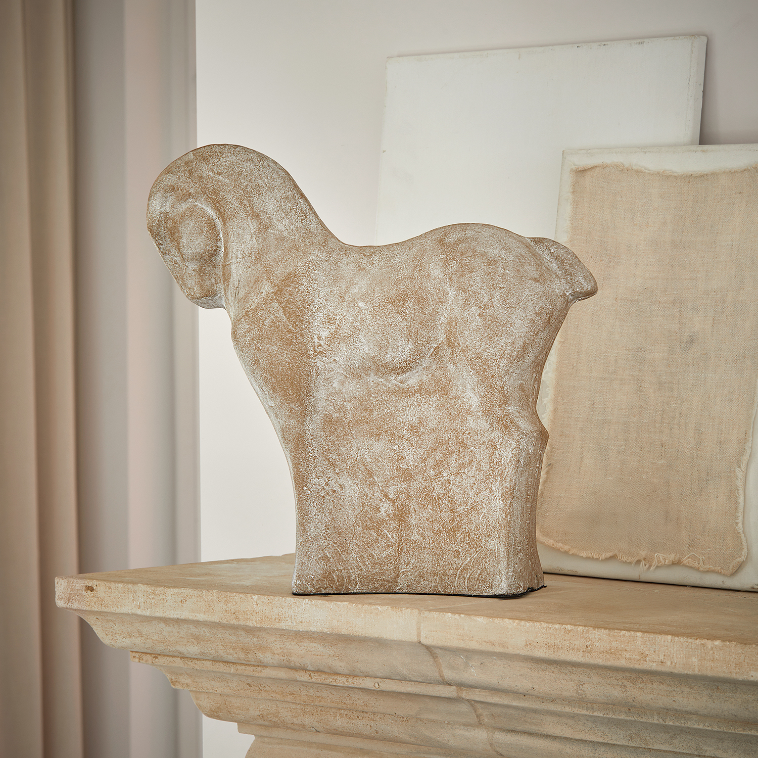 Decoratief beeld van een ram van beige steen op een stenen schoorsteenmantel