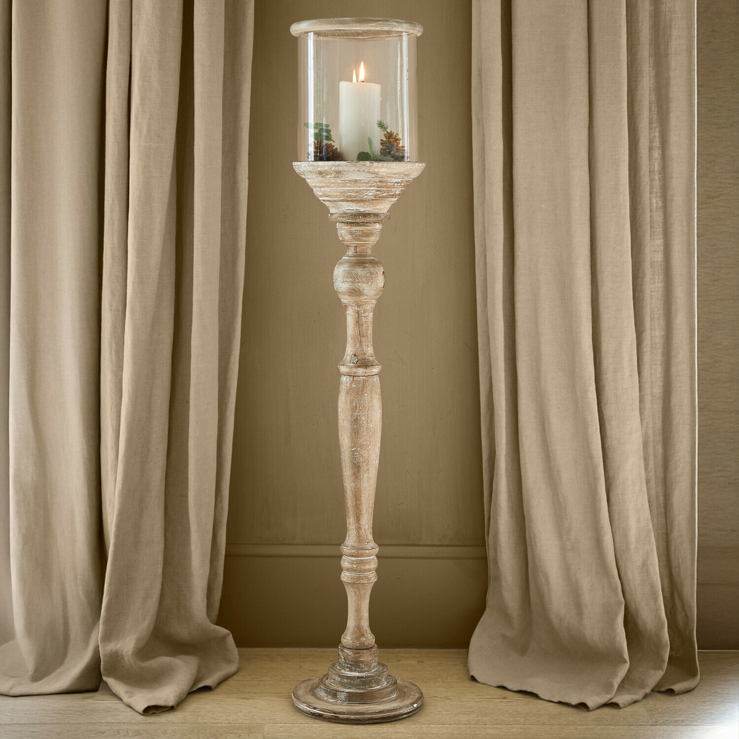 Bougeoir Passion Fauteuil en bois avec coussins verts dans un intérieur lumineux et naturel avec un lampion décoratif