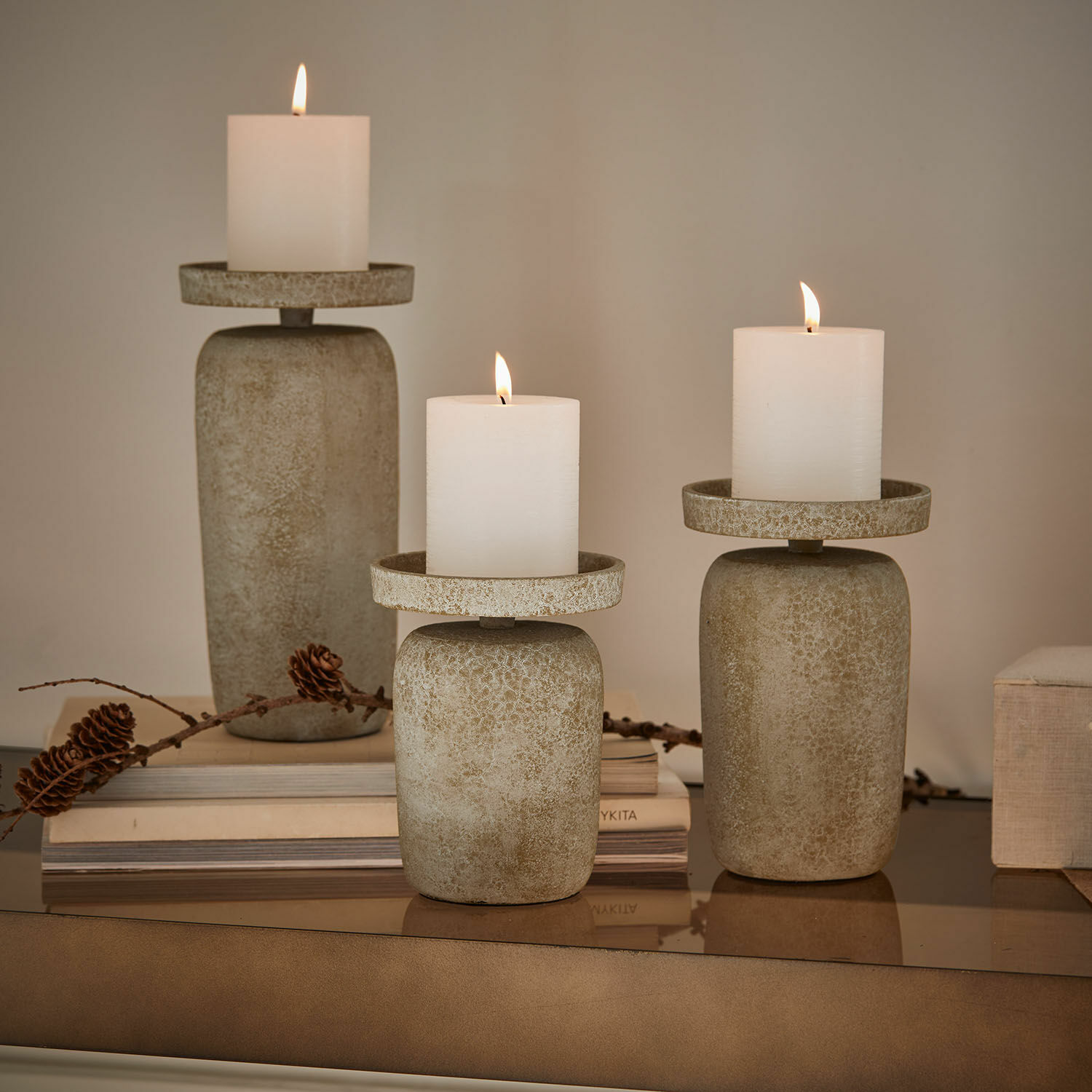 Lot de 3 bougeoirs Amsley Ensemble de trois bougeoirs en pierre beige avec bougies blanches, décoration intérieure élégante