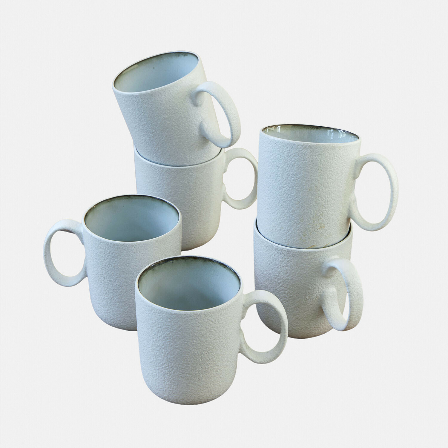 Set van zes witte keramische mokken met ruwe textuur en grijze binnenkant voor koffie en thee