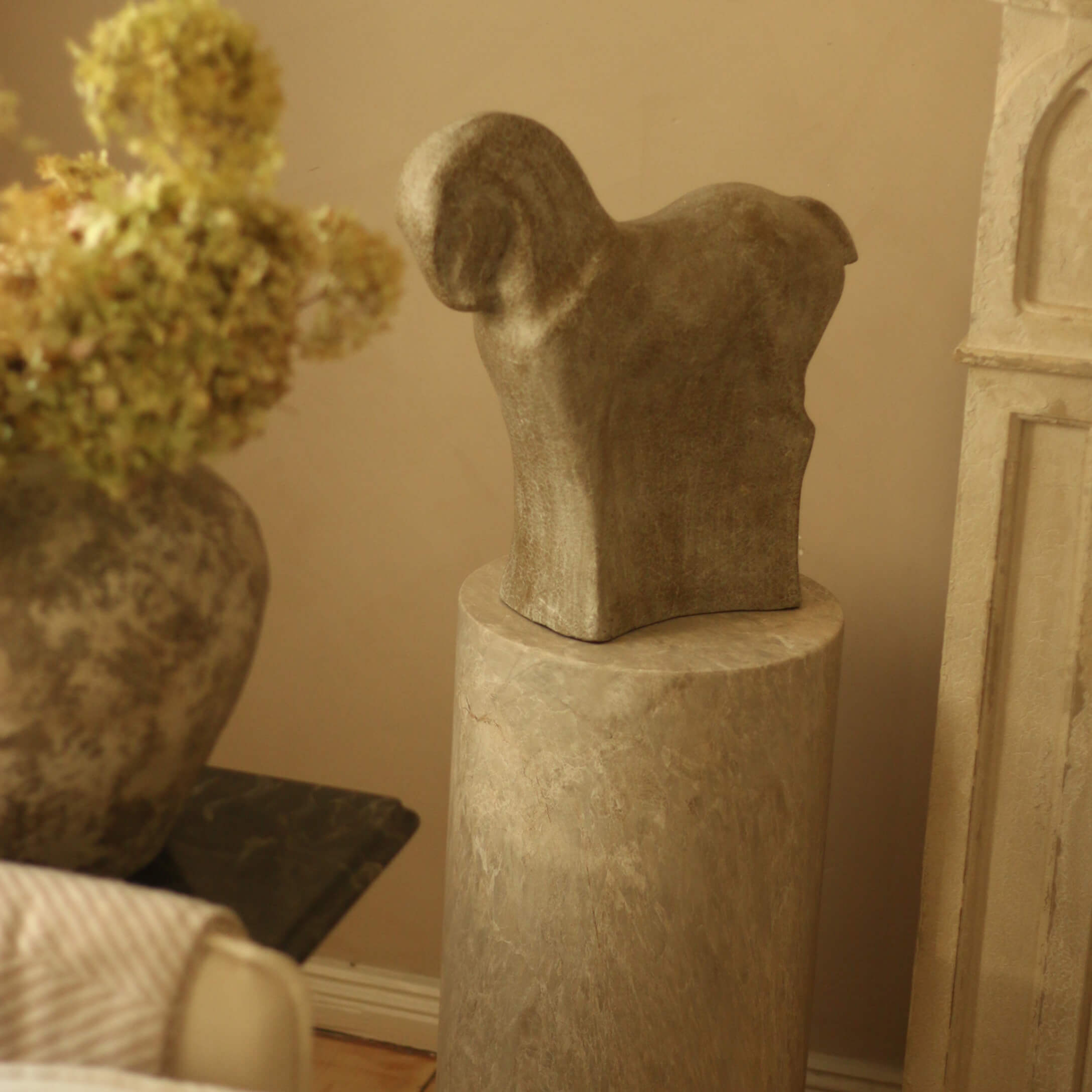 Sculpture en pierre représentant un animal sur un socle en marbre dans un intérieur chaleureux