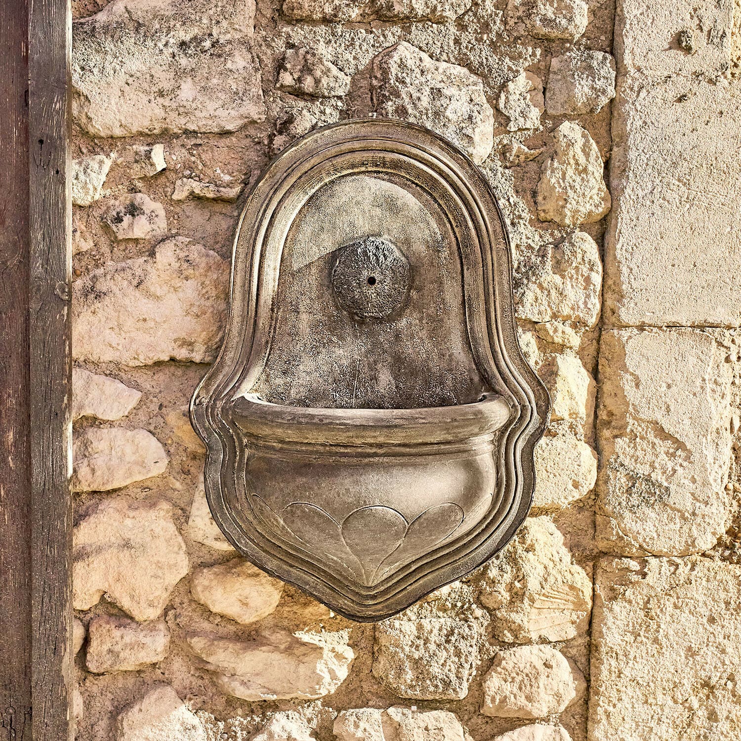Fontaine murale Veliras Fontaine murale décorative en pierre grise fixée sur un mur en pierres, décoration extérieure