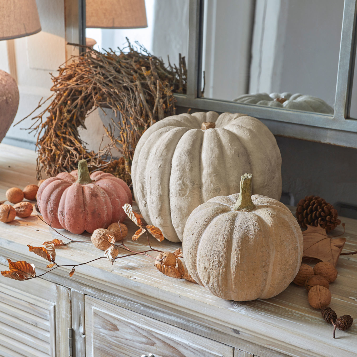 Lot de 3 citrouilles Pumpkin Citrouilles décoratives en béton beige et rose sur une commode en bois avec accessoires d'automne