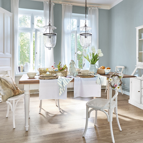 Rustieke eetkamer met witte houten tafel en stoelen, lichte pastelkleuren decoraties